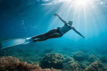 Freediver woman with long fins in tropical sea