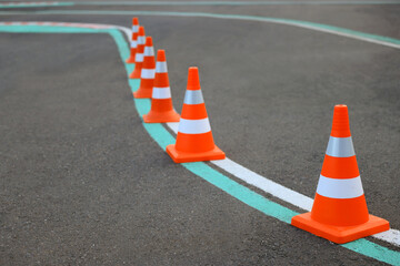 Driving school test track with marking lines, focus on traffic cone