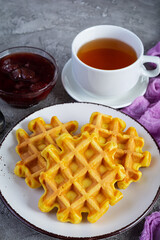 Sweet pumpkin waffles with strawberry jam. Delicious breakfast with belgian waffles