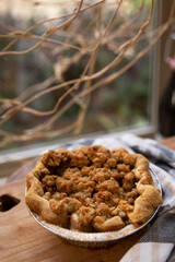 Homemade mini apple crumble pie in window sill