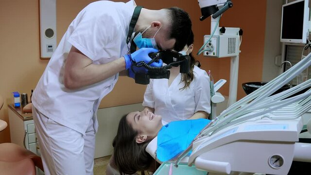 The dentist takes pictures of the patient's teeth after treatment.