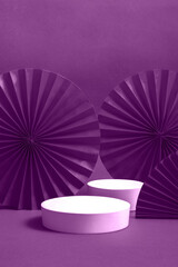 White podium or pedestal with decorative red paper fans on a violet background. Product presentation concept. copy space