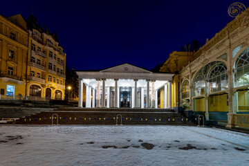 Fototapeta na wymiar Mariánské Lázně (Marienbad) - white columns pavilion of mineral water spring in winter - evening on the spa colonnade