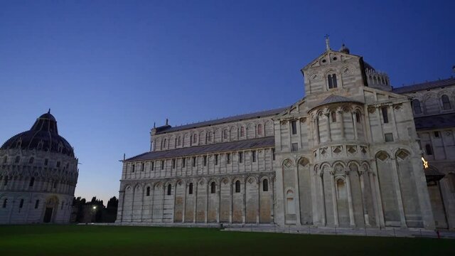 Sunset Piazza dei Miracoli - Pisa, Italy, January 2021: Cathedral medieval Roman Catholic Assumption of the Virgin Mary in Piazza dei Miracoli and Pisa leaning tower	
