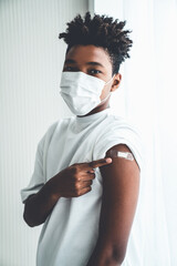 Fototapeta African American teenager showing COVID-19 vaccine bandage merrily in concept of coronavirus vaccination program to vaccinate citizen . obraz
