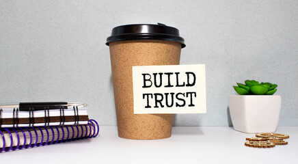 Business and finance concept. On the table are a pen and a notebook with the inscriptions - Build trust.