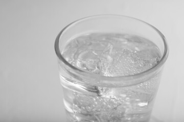 Glass of soda water on light grey table, closeup