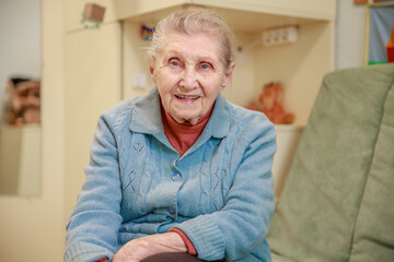 Grandmother alone at home, loneliness, an old woman with a wrinkled face in the room, caring for the older generation, great-grandmother.
