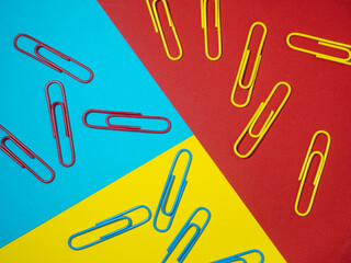 Colored paper clips on paper. Office supplies.  Colorful office supplies.