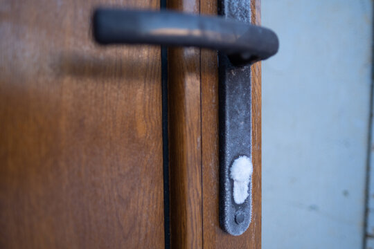 The frozen door lock is covered with an incredibly beautiful pattern of ice