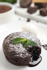 Delicious fresh fondant with hot chocolate, mint and ice cream served on white table, closeup