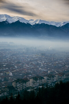 Pirin mountain, Bulgaria. Covered in snow peak in winter skiing season. Mist fog and Razgrad city below the mountain