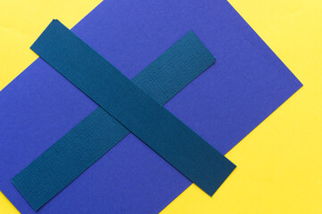 blue x on purple and yellow paper