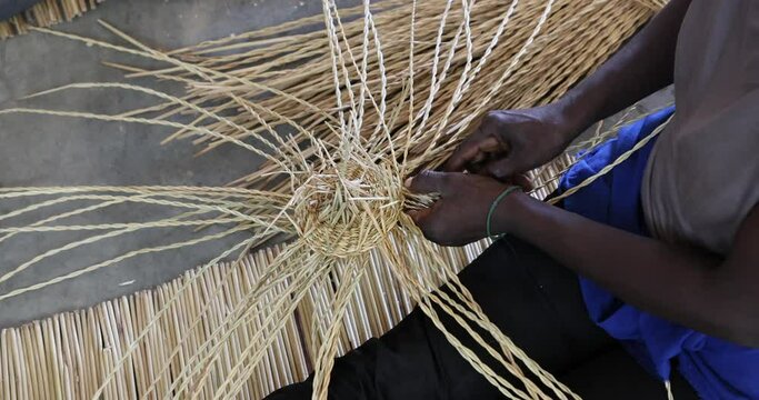 African Woman making a grass basket traditional village Ghana. Northern Ghana art  craft village specializing in pottery, baskets, leather and painting. Income producer for tourism and export world.