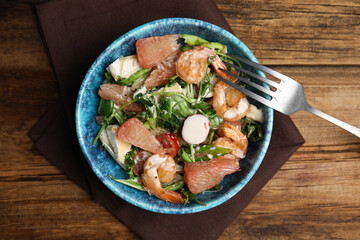 Delicious pomelo salad with shrimps served on wooden table, flat lay
