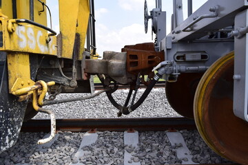 Parked train carriages zooming in on the wheels, zooming in on the hitch between carriages, carriages on a curve