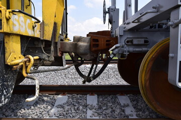 Parked train carriages zooming in on the wheels, zooming in on the hitch between carriages, carriages on a curve