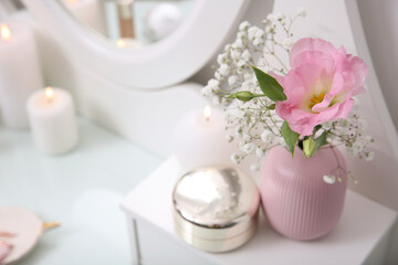 Fototapeta na wymiar Beautiful flowers in vase and decor on white dressing table
