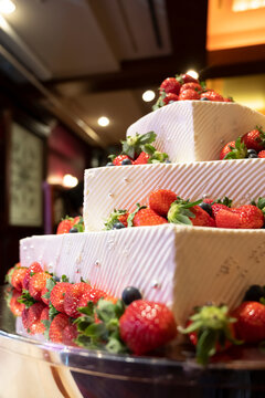 A cake full of strawberries on each stage