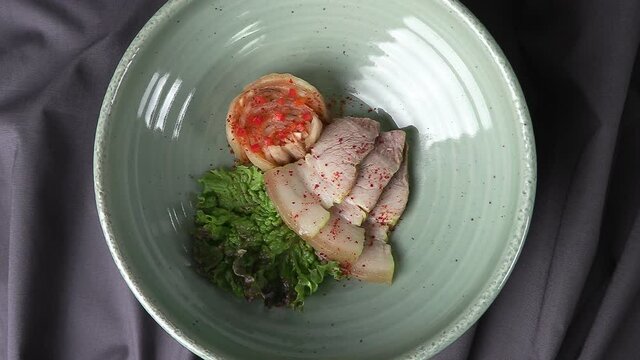 Bossam and kimchi in a ceramic bowl. Pork dishes that are popular with Koreans.
