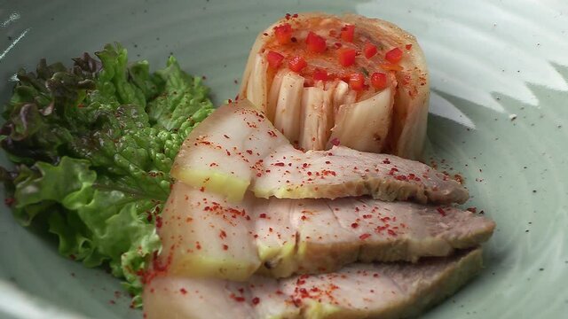 Bossam and kimchi in a ceramic bowl. Pork dishes that are popular with Koreans.
