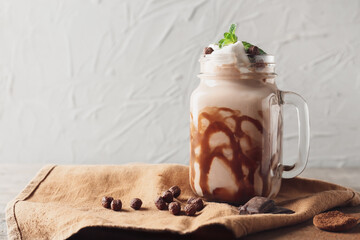 Mason jar of sweet cocoa drink on grunge background