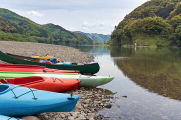 四万十川の河原に置かれているカヌーやカヤックなどアウトドアスポーツに使用する小船