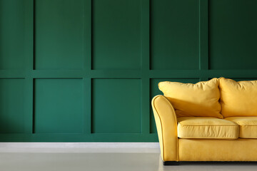 Cozy yellow couch near green wall