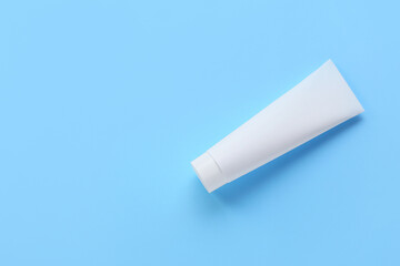 Tube with tooth paste on blue background