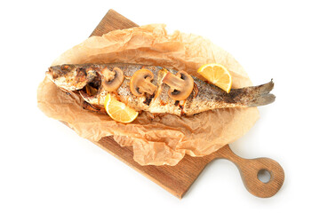Wooden board with delicious sea bass fish, lemon and mushrooms on white background