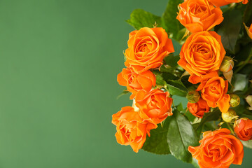 Bouquet of beautiful orange roses on green background