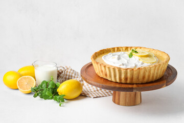 Stand with delicious lemon tart on light background
