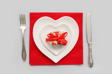 Stylish table setting and gift for Valentine's Day on light background