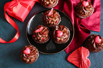 Plate with tasty chocolate cupcakes for Valentine's day on dark background