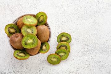 Bowl with fresh cut kiwi on light background
