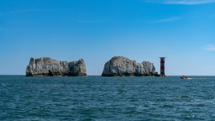 View of High Speed RIB Boat Next to The Needles Lighthouse and chalk rocks in Alum Bay, Isle of Wight, United Kingdom