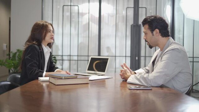 couple talking and working with laptop computer together in office.  business woman take note from discussion with customer. lawyer Write a message from a conversation with desperate client . stressed