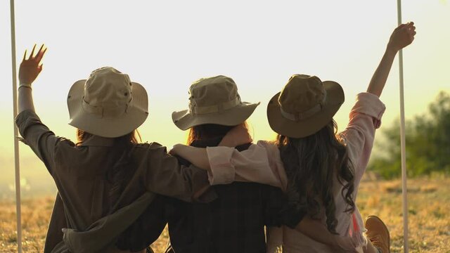 Friendship group of Asian young women having fun and enjoy Sit together, cuddle, and watch the sunset. outdoor camping trip in nature, Females Lifestyle Vacations Relaxation. slow motion