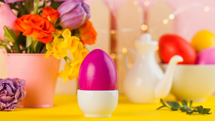 Easter card. Colorful Easter eggs on the background of a bouquet of flowers.