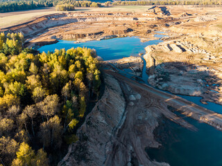 Surviving forest area on the border with the development of a large sand pit, aerial view