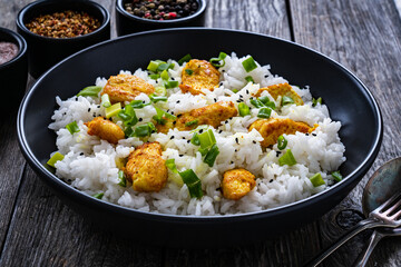Chicken nuggets with rice and vegetables on wooden table
