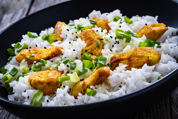 Chicken nuggets with rice and vegetables on wooden table
