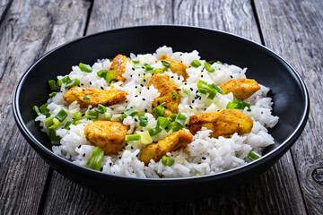 Chicken nuggets with rice and vegetables on wooden table
