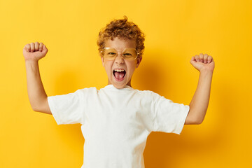 Photo portrait curly little boy in a white T-shirt with glasses gesturing with his hands isolated background unaltered