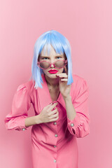 portrait of a woman in blue wig pink dress red lips isolated background