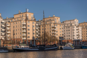 Apartment houses and a pier with sailing boats at the bay Hammarby sjö in the district Södermalm...