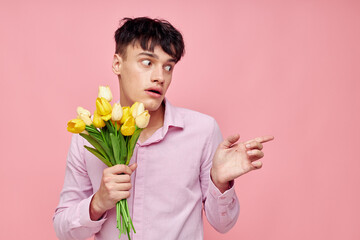 Photo of romantic young boyfriend Bouquet of yellow flowers romance posing fashion pink background unaltered