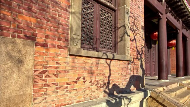 Time-lapse of the shadows of the trees moving on the wall of the ancient Chinese buildings under the sunlight