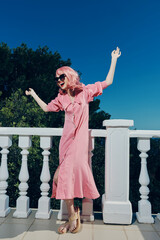 beautiful woman pink dress modern style stands near the railing Lifestyle