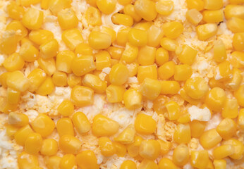 Salad of eggs and corn kernels as a background.